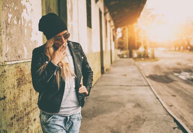 Legal Public Cannabis Use with Style and Discretion. Happy woman enjoying sunny day discreetly smoking weed in public legally.